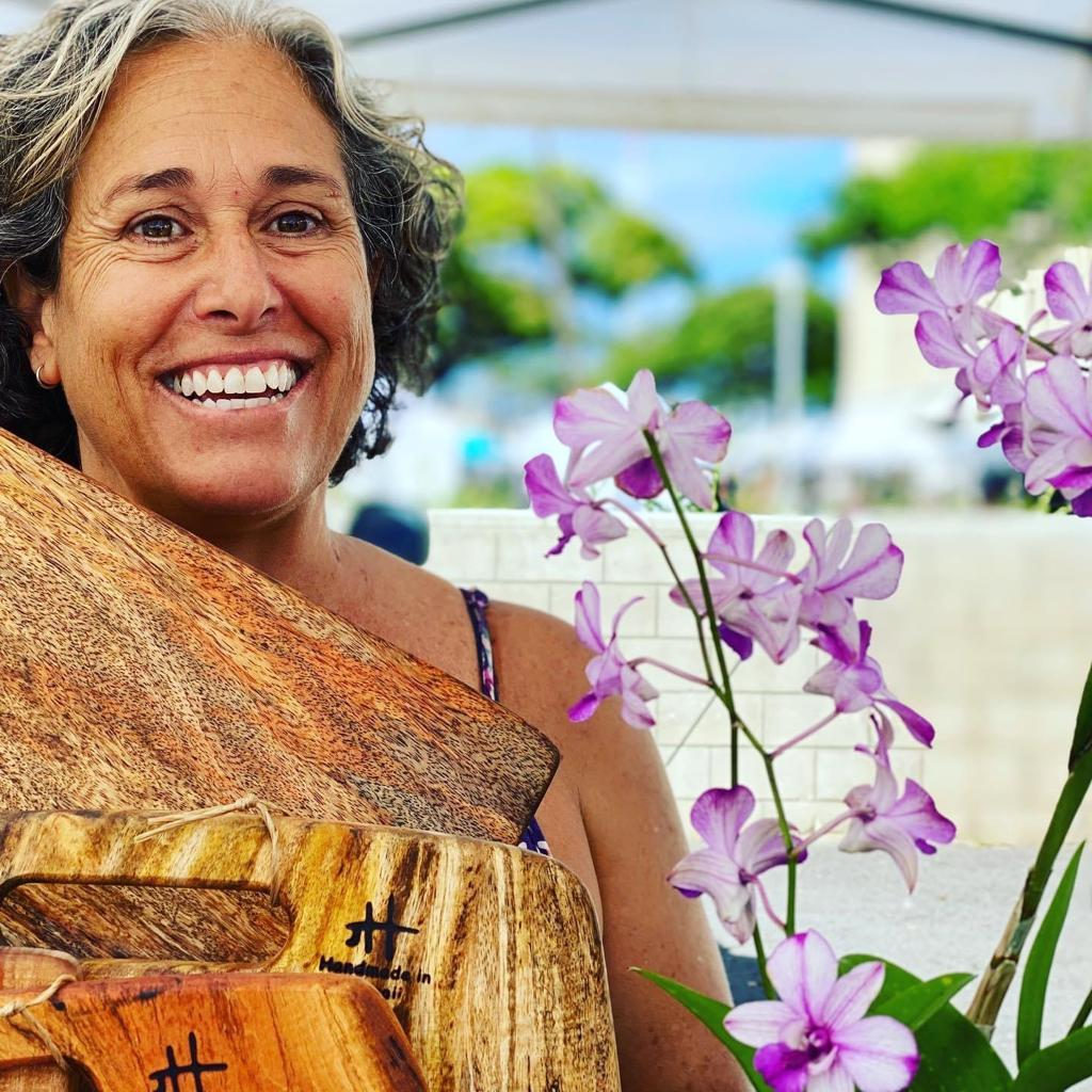 Jen at the Foundwood booth, orchids and finished boards around her.