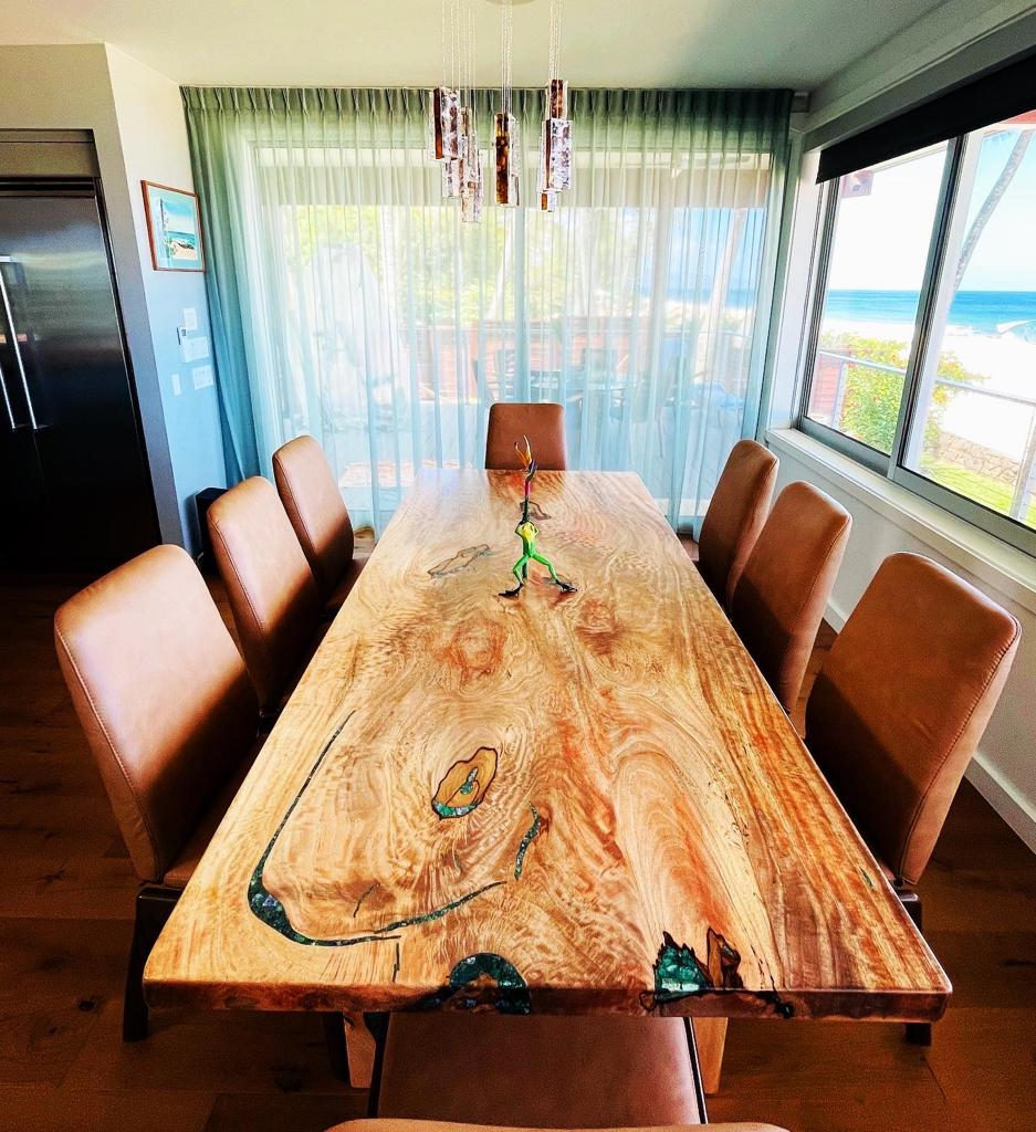 Single-slab dining table before an ocean-view window.