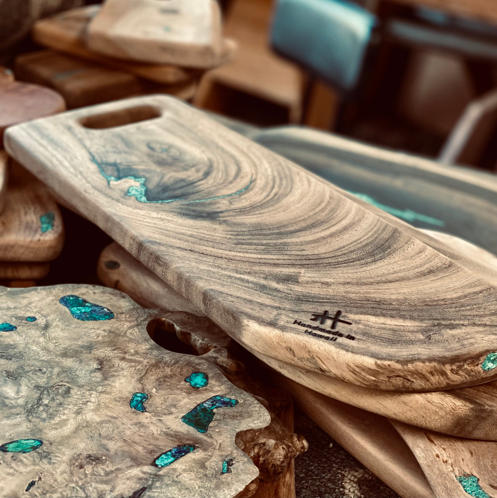 Cutting boards stacked at the market booth, chrysocolla catching the light.