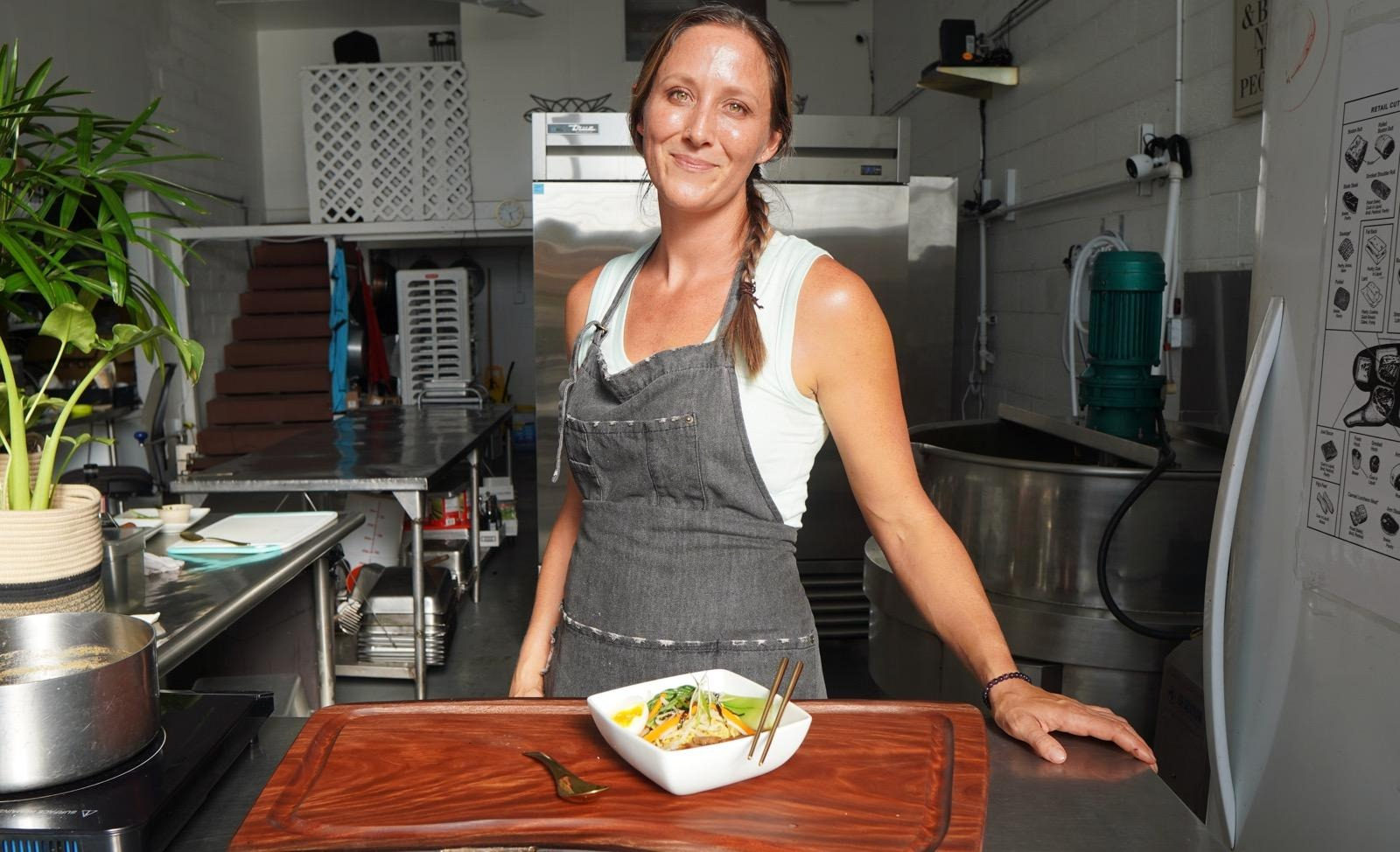 Jess Rohr of Forage serving a noodle bowl on a Foundwood mango board in her kitchen.